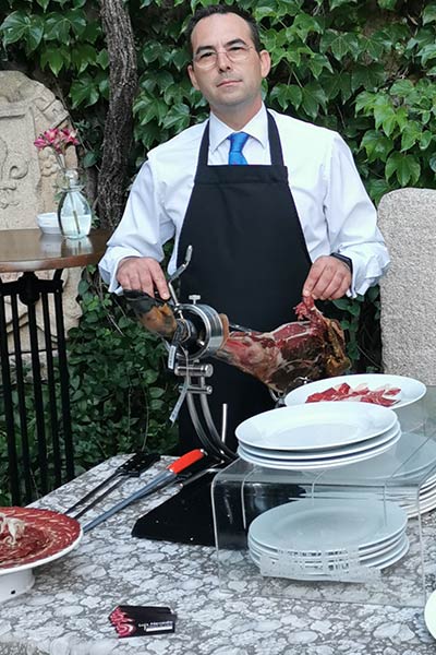 Luis Nevado cortando jamón en un evento